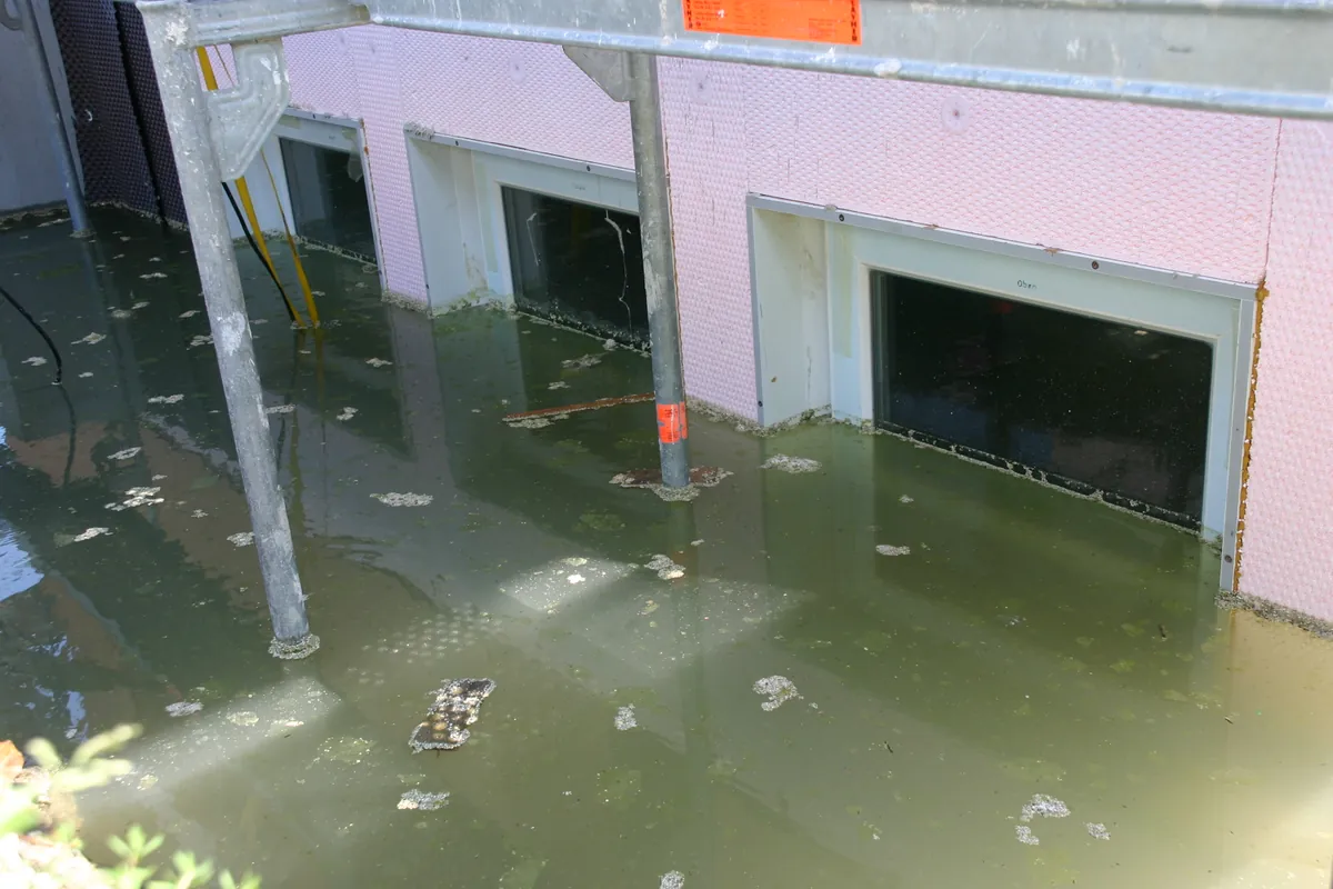 Drei Kellerfenster komplett unter Wasser im Lichtschacht als Beweis für wasserdichte Sanierungsfenster