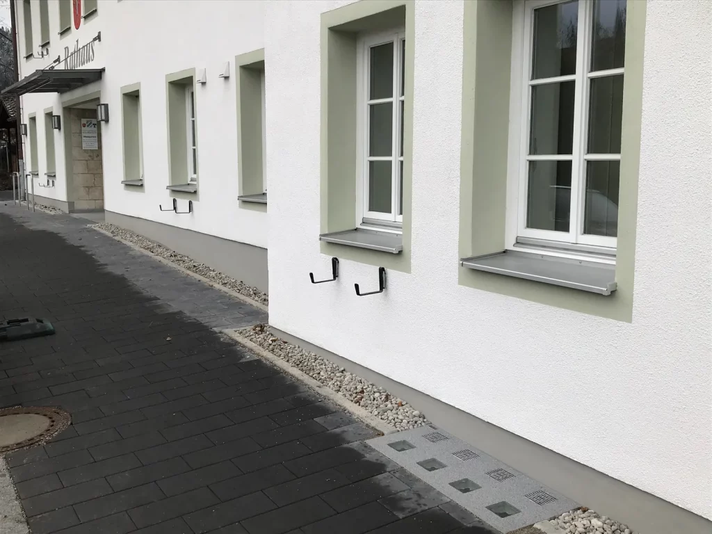 Wasserdichte Lichtschachtabdeckung am Sockel eines Rathauses in der Region Rhein-Neckar